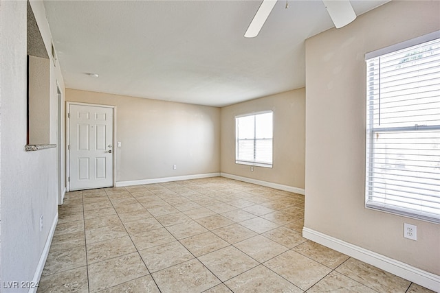 spare room with ceiling fan and light tile patterned flooring