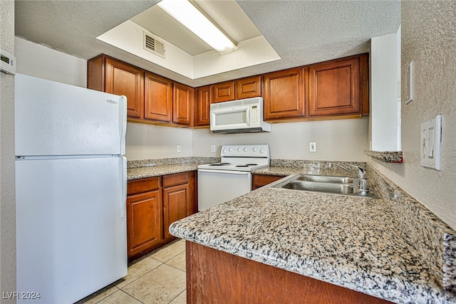 kitchen featuring white appliances, a textured ceiling, light tile patterned flooring, and sink