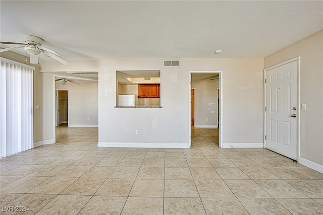 tiled empty room featuring ceiling fan