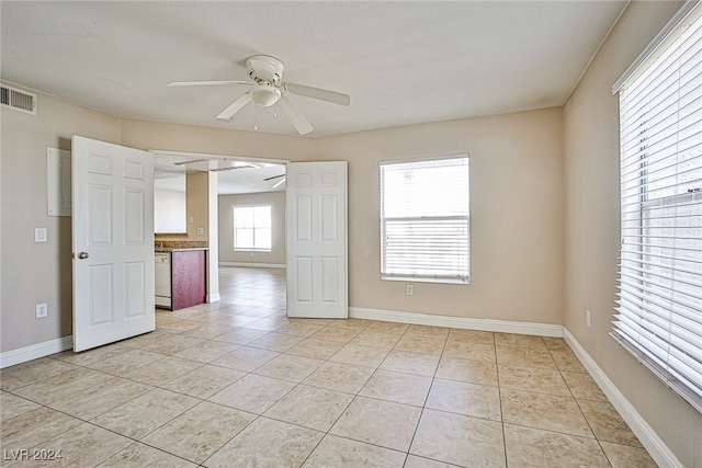 interior space featuring ceiling fan and a wealth of natural light