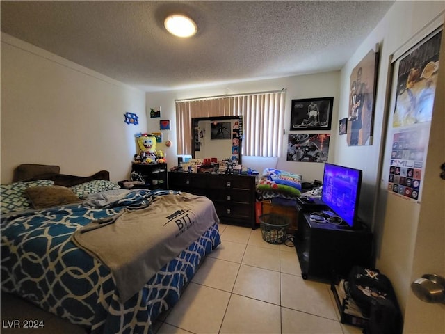 bedroom featuring light tile patterned flooring and a textured ceiling