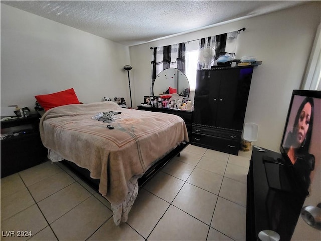 bedroom featuring light tile patterned floors and a textured ceiling