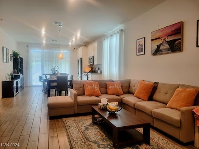 living room featuring a wealth of natural light and light hardwood / wood-style floors