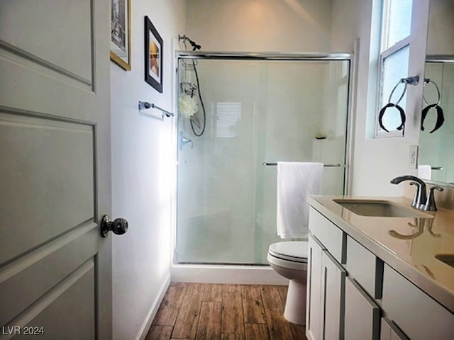 bathroom with vanity, toilet, hardwood / wood-style floors, and walk in shower