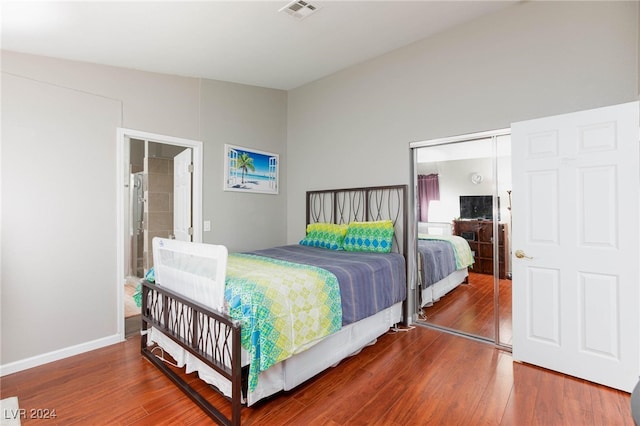 bedroom featuring a closet, dark hardwood / wood-style flooring, and ensuite bath