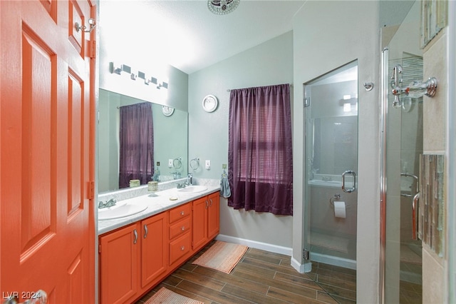 bathroom featuring vanity, a shower with shower door, and vaulted ceiling