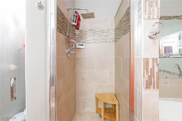 bathroom with toilet and a tile shower