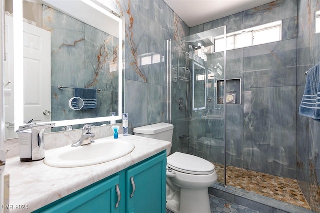 bathroom featuring a shower with door, vanity, toilet, and tile patterned flooring