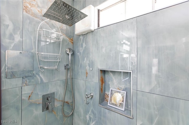 bathroom featuring tile walls and a tile shower