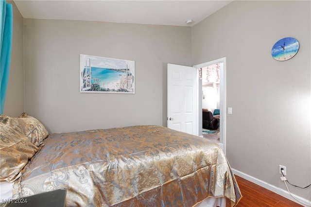 bedroom with vaulted ceiling and dark hardwood / wood-style floors