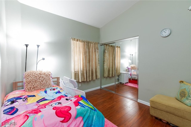 bedroom with dark wood-type flooring, a closet, and high vaulted ceiling