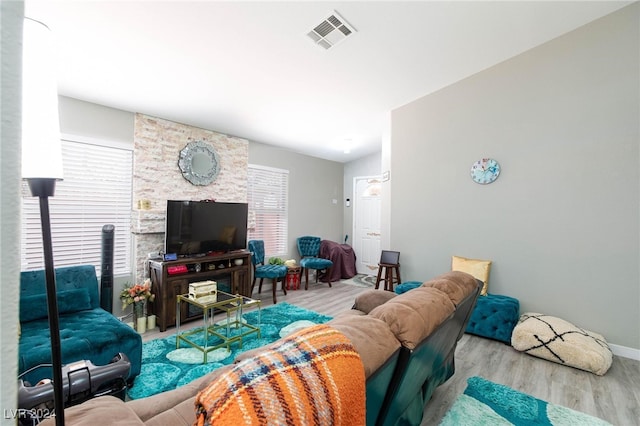 living room featuring vaulted ceiling, a healthy amount of sunlight, and light hardwood / wood-style floors