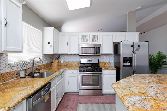 kitchen featuring stainless steel appliances, decorative backsplash, white cabinetry, and sink