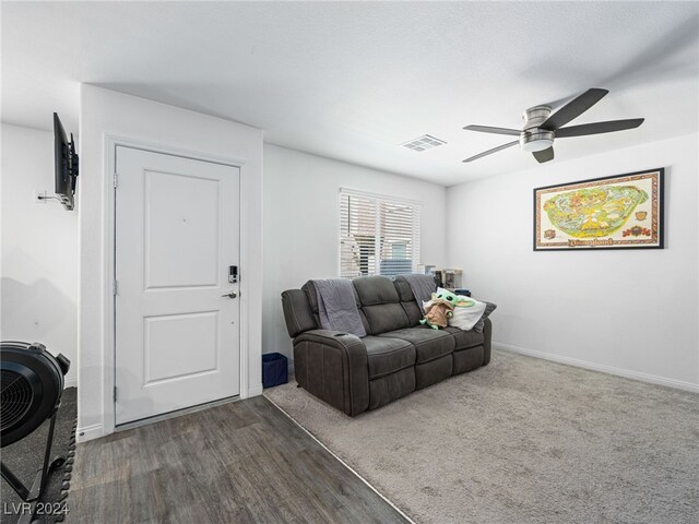 living room featuring ceiling fan and dark hardwood / wood-style floors