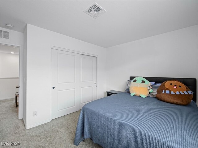 bedroom with a closet and light carpet