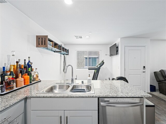 kitchen featuring dishwasher, dark hardwood / wood-style flooring, sink, light stone countertops, and gray cabinetry