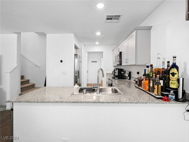 kitchen featuring kitchen peninsula, dark hardwood / wood-style floors, stainless steel appliances, and white cabinets