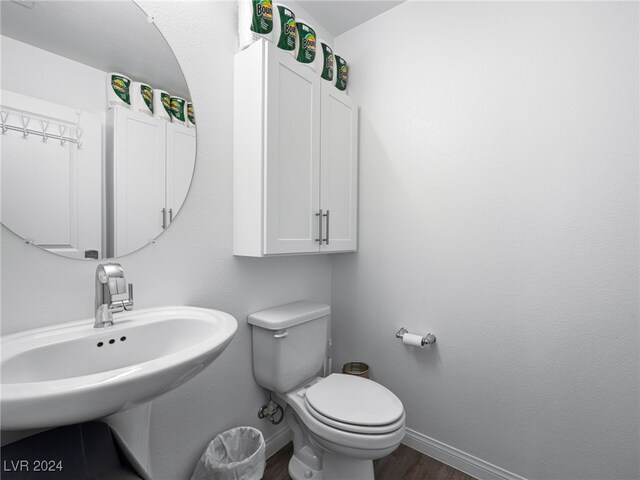 bathroom with toilet, sink, and hardwood / wood-style floors