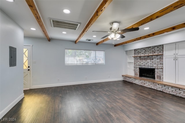 unfurnished living room featuring dark hardwood / wood-style floors, beam ceiling, ceiling fan, electric panel, and a brick fireplace