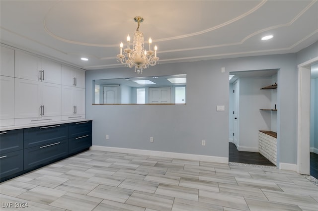 dining space with an inviting chandelier and a tray ceiling