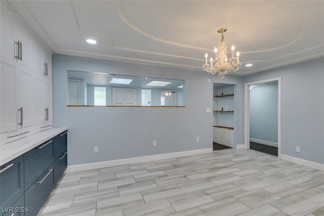 interior space with a tray ceiling and a notable chandelier