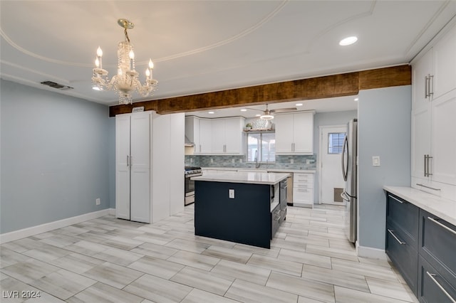 kitchen featuring hanging light fixtures, white cabinetry, appliances with stainless steel finishes, and a center island