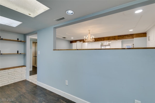 unfurnished dining area featuring dark hardwood / wood-style floors and an inviting chandelier