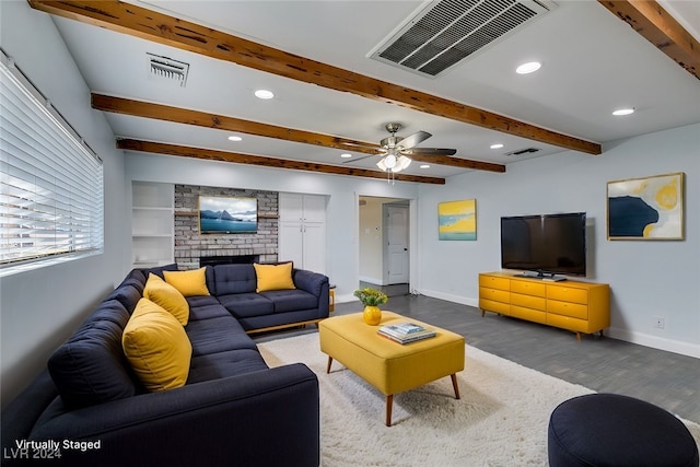 living room featuring a fireplace, wood-type flooring, ceiling fan, and beam ceiling