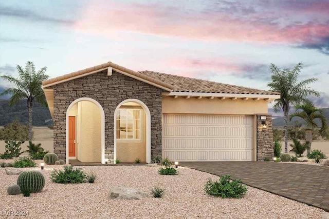 view of front of house featuring driveway, a tiled roof, an attached garage, and stucco siding