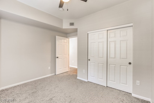 unfurnished bedroom with a closet, ceiling fan, and light carpet