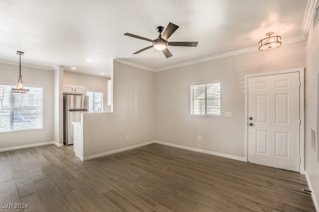 unfurnished room featuring dark wood-type flooring, ceiling fan with notable chandelier, and crown molding