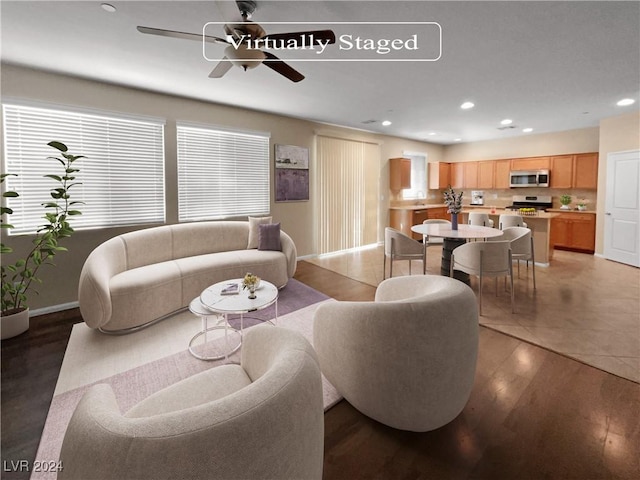 living area featuring a ceiling fan, recessed lighting, baseboards, and wood finished floors