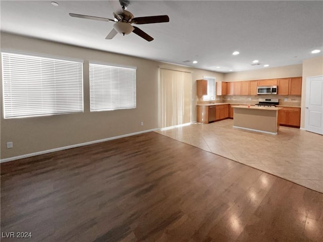 kitchen featuring light wood finished floors, open floor plan, stainless steel appliances, light countertops, and recessed lighting