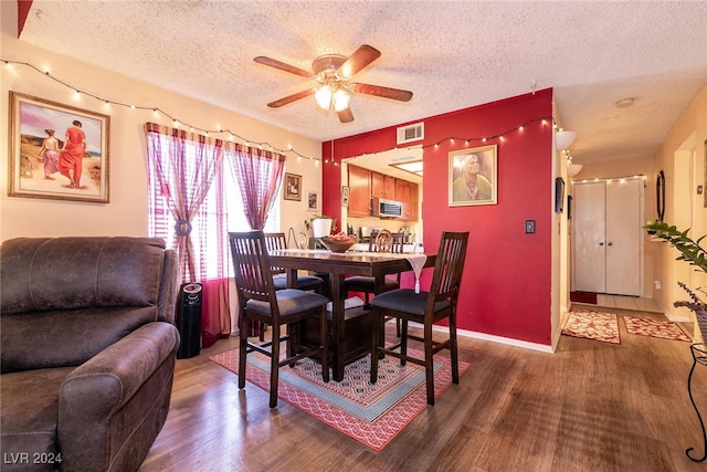 dining space featuring a textured ceiling, ceiling fan, and dark hardwood / wood-style flooring