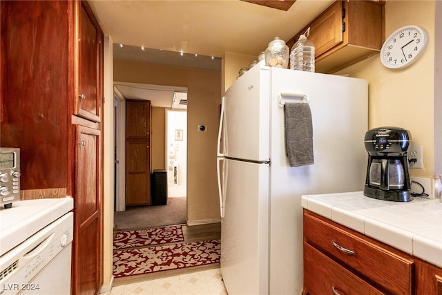 kitchen featuring white appliances and tile countertops