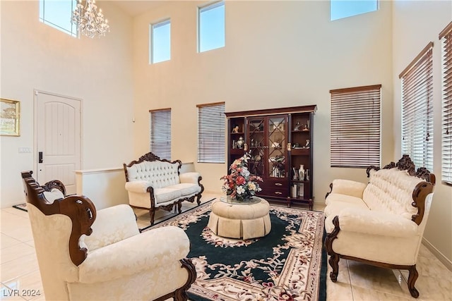 living room featuring light tile patterned floors, a high ceiling, and an inviting chandelier