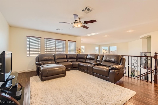 living room with ceiling fan and dark wood-type flooring