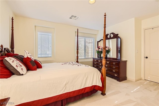 bedroom with light carpet and multiple windows