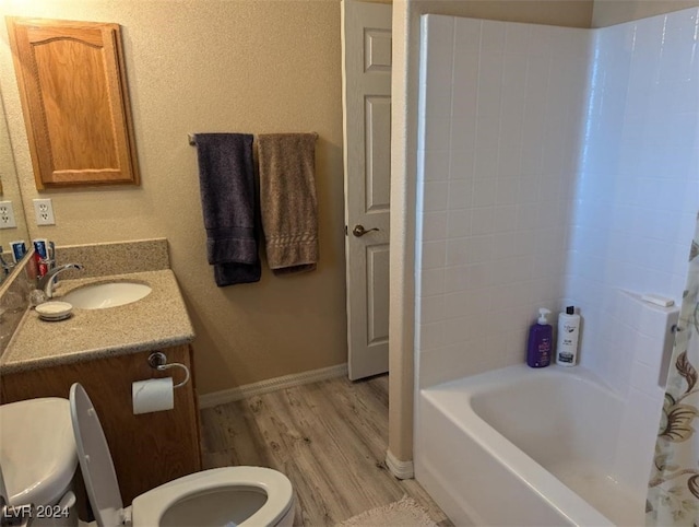 full bathroom featuring vanity, hardwood / wood-style floors, toilet, and shower / bathtub combination with curtain