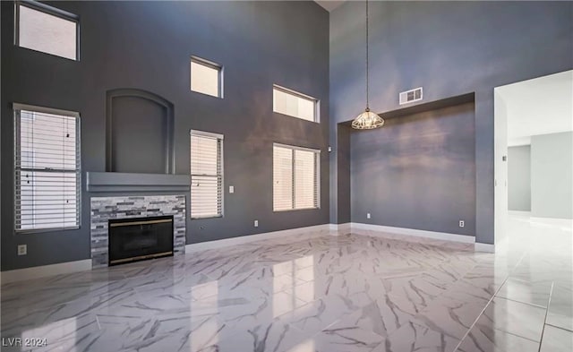 unfurnished living room with a towering ceiling and a fireplace