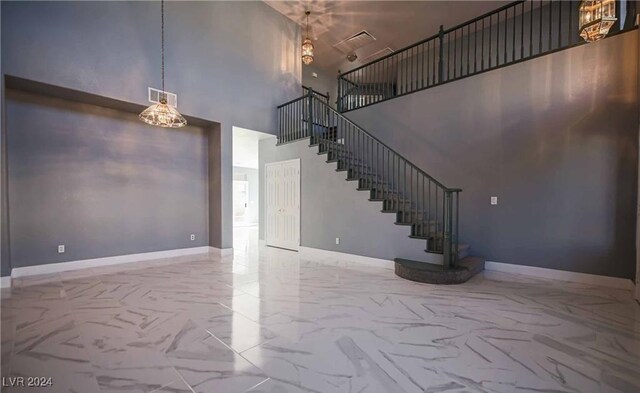 unfurnished living room featuring a towering ceiling