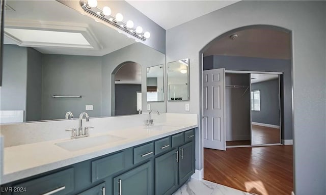 bathroom with lofted ceiling, vanity, and hardwood / wood-style floors