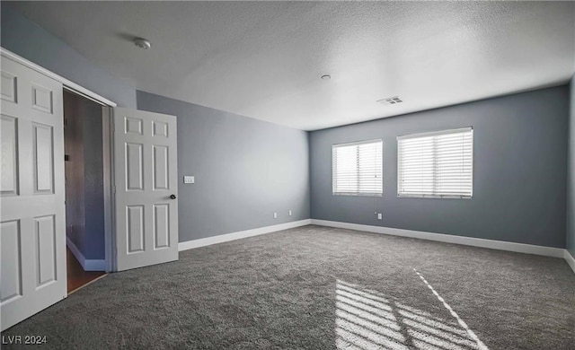 unfurnished room with a textured ceiling and carpet