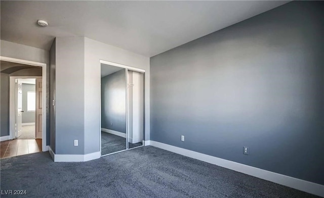 unfurnished bedroom featuring carpet and a closet