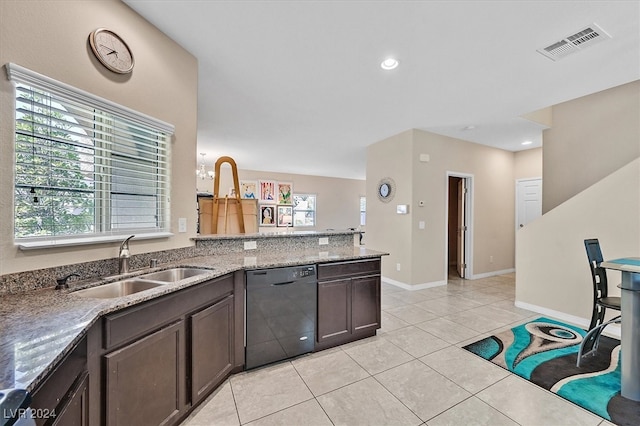 kitchen with dishwasher, light tile patterned floors, sink, light stone counters, and dark brown cabinetry