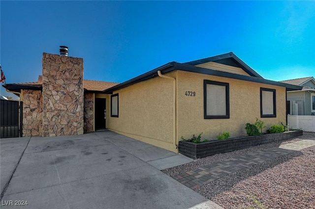 4729 Bennett Dr, Las Vegas, NV 89121 - view of side of home featuring a chimney, stucco siding, and fence