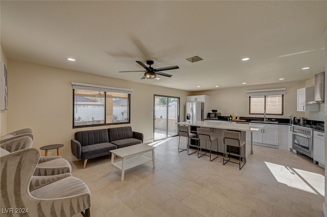 living room featuring ceiling fan and sink