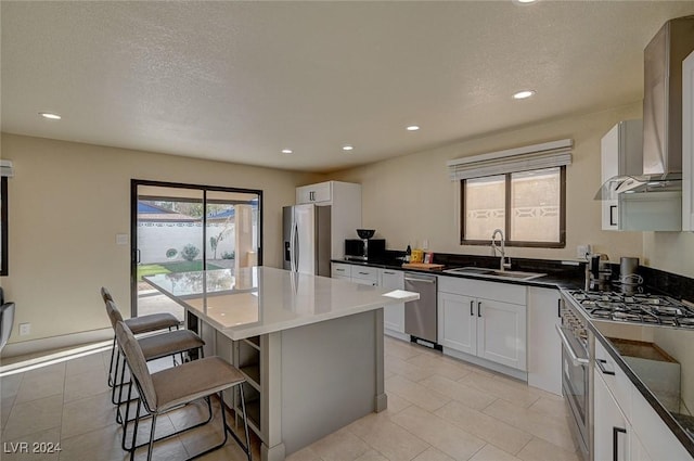 4729 Bennett Dr, Las Vegas, NV 89121 - kitchen featuring a center island, wall chimney exhaust hood, a sink, a kitchen bar, and stainless steel appliances