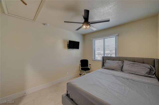 bedroom with ceiling fan and a textured ceiling