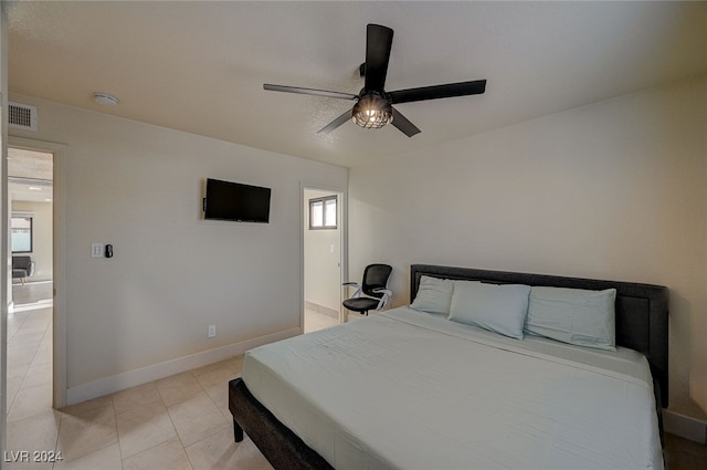 tiled bedroom featuring multiple windows and ceiling fan